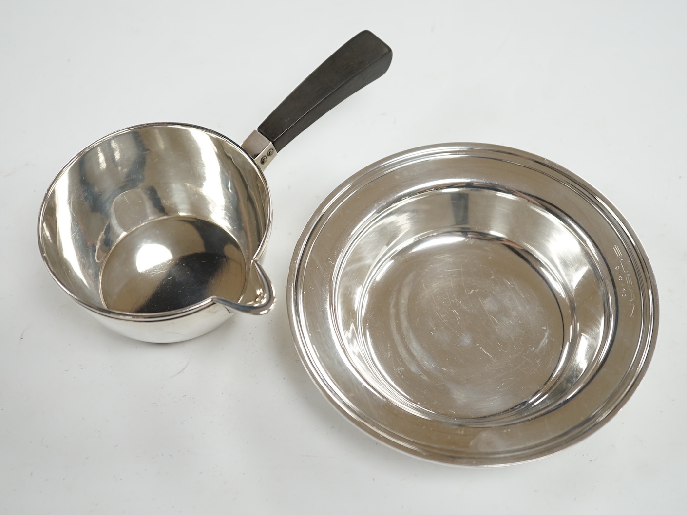 A 1940's Danish white metal bowl and small saucepan with wooden handle, the latter stamped Heimburger, gross 8.4oz. Condition - fair